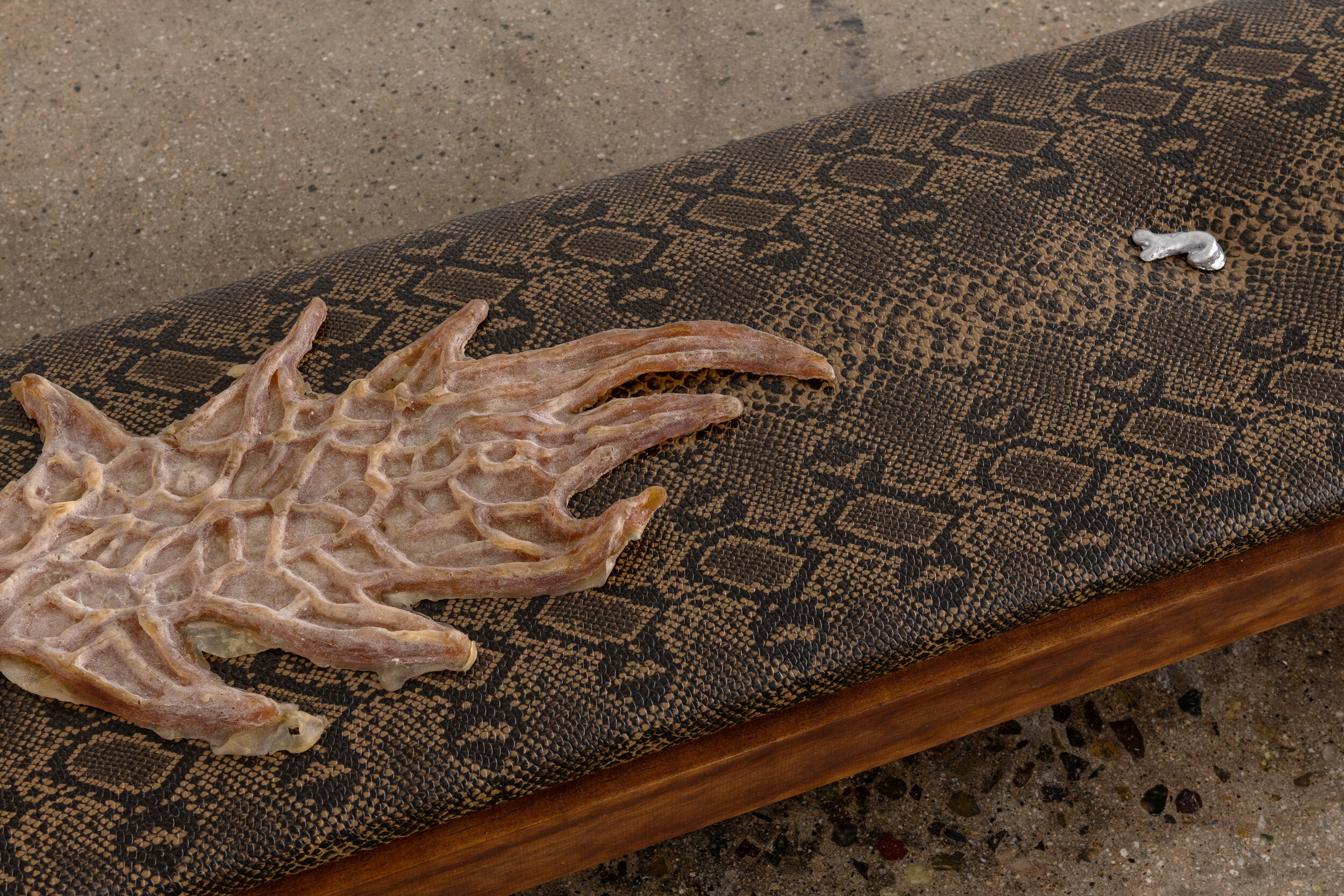  Detail view of   Sessa Englund   Upholstered skeleton structure with skin, heart and snakeskin (structure series)  2021 Cherry wood, upholstery fabric, leather, carving, soot, cast latex, cast tin 