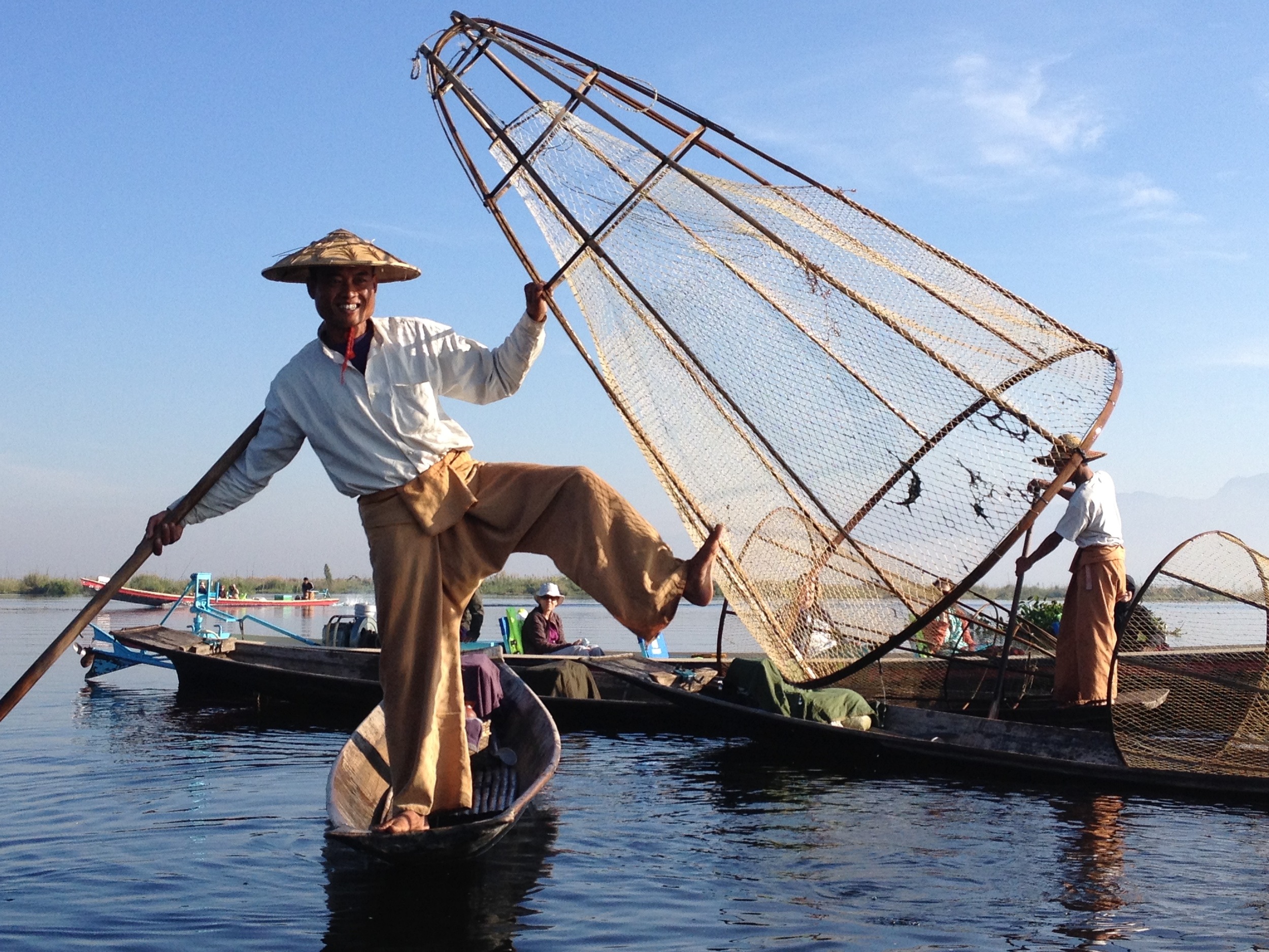 A fisherman on Inle Lake demonstrates how they use three limbs at a time to maneuver their boat while trapping fish.