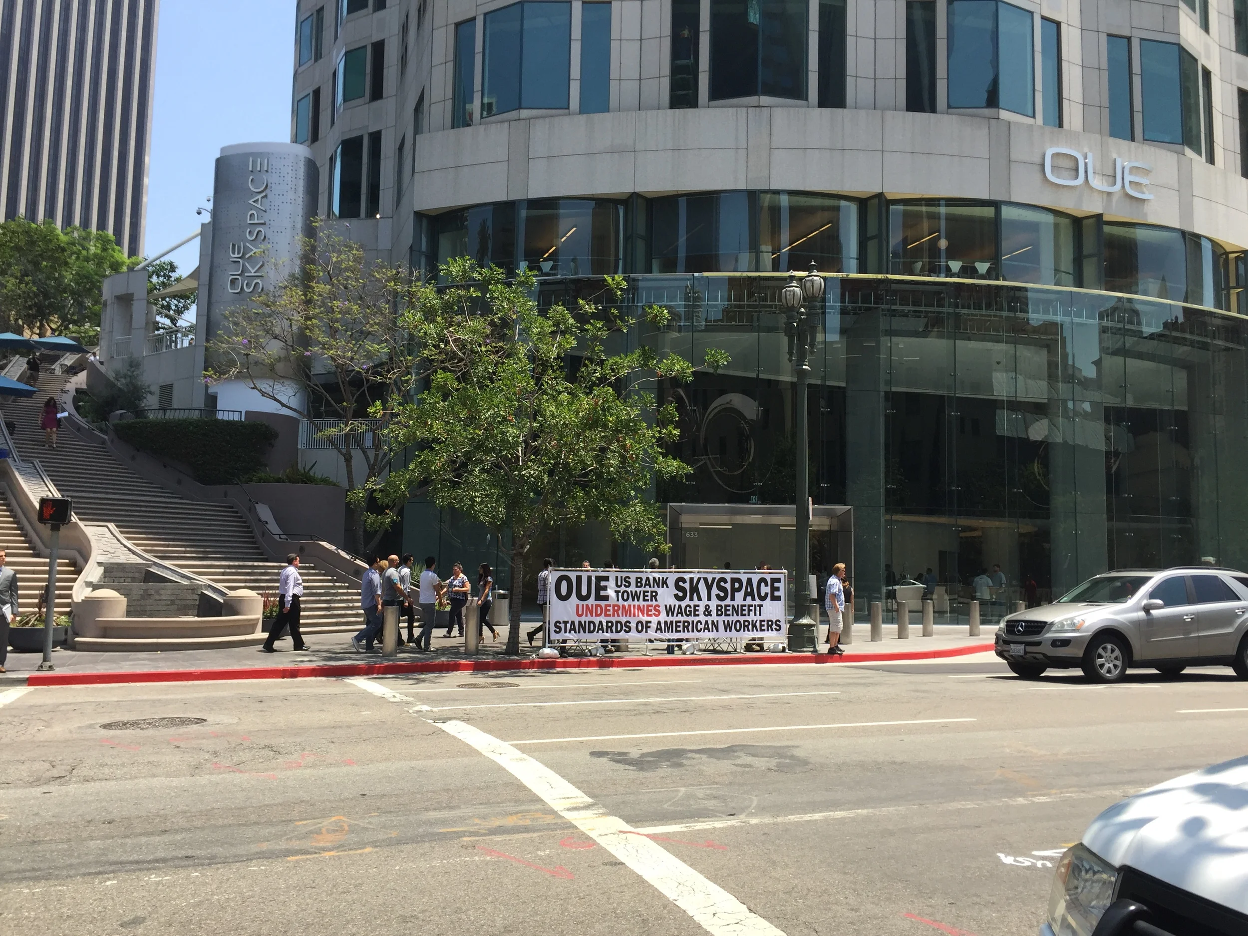 Protesters utilize the space between the curb and the bollards outside the U.S. Bank Tower. (photo by David Douglass-Jaimes)