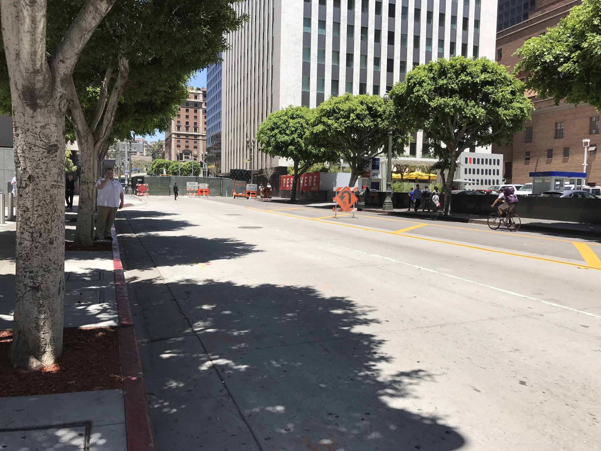 The half-block, dead end section of 6th Street, that inexplicably warrants a protected left turn signal from northbound Hope Street. Note the zero cars on the street at the time of this photo, the one bicyclist, and one jaywalking pedestrian.