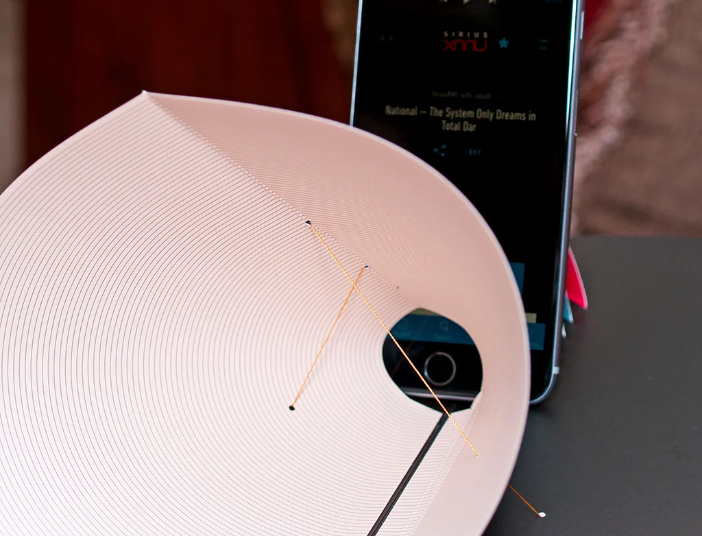 The pop up holds the cellphone at the cone, which amplifies the sound level of the playing music.