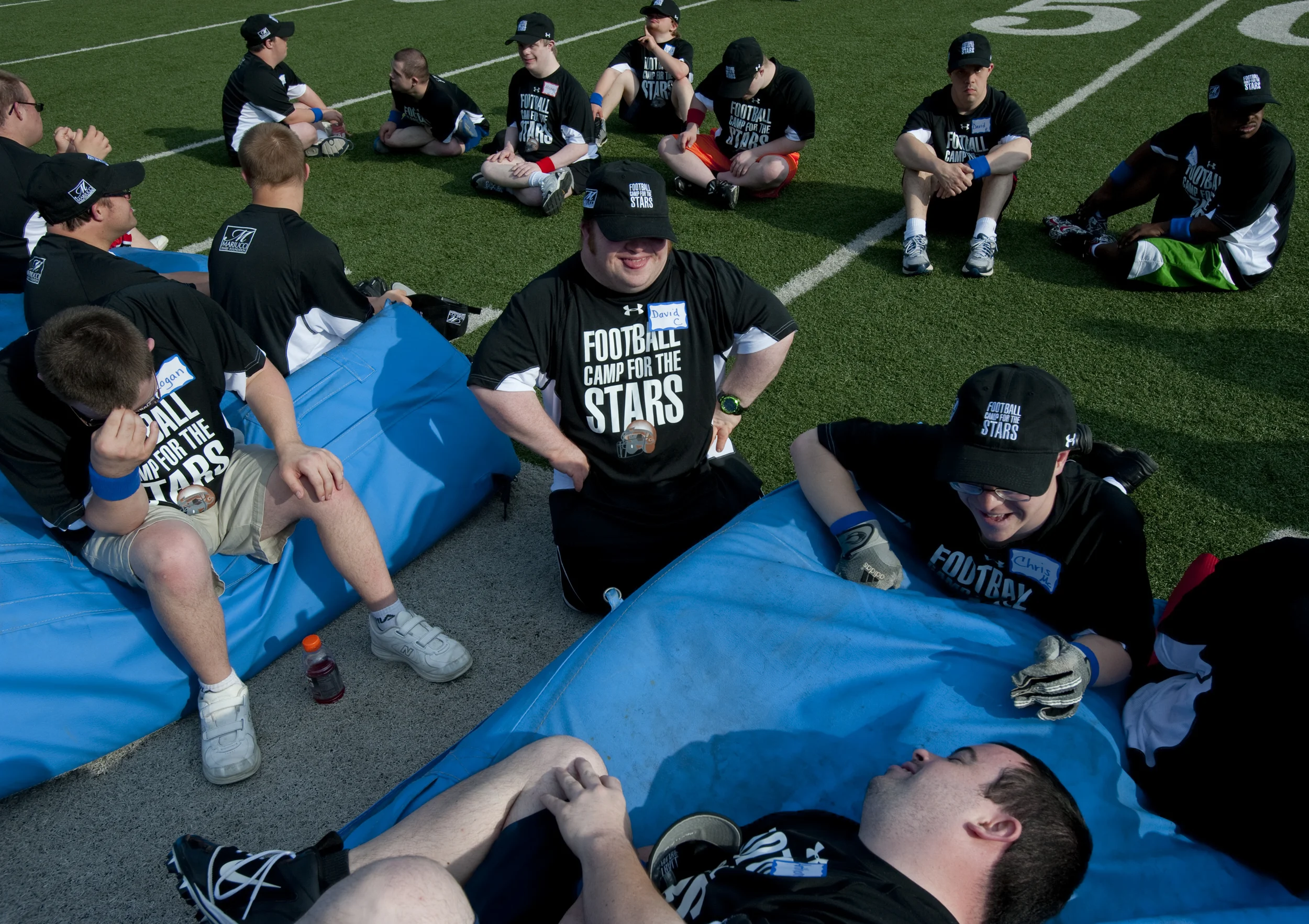   David Caliendo, middle, Chris McGough, right, and Anthony Curigliano, bottom, makes jokes together before the start of the Camp for the Stars practice, a football camp for people with Down Syndrome ages 15 to 30 that took place at the Woodland Hill
