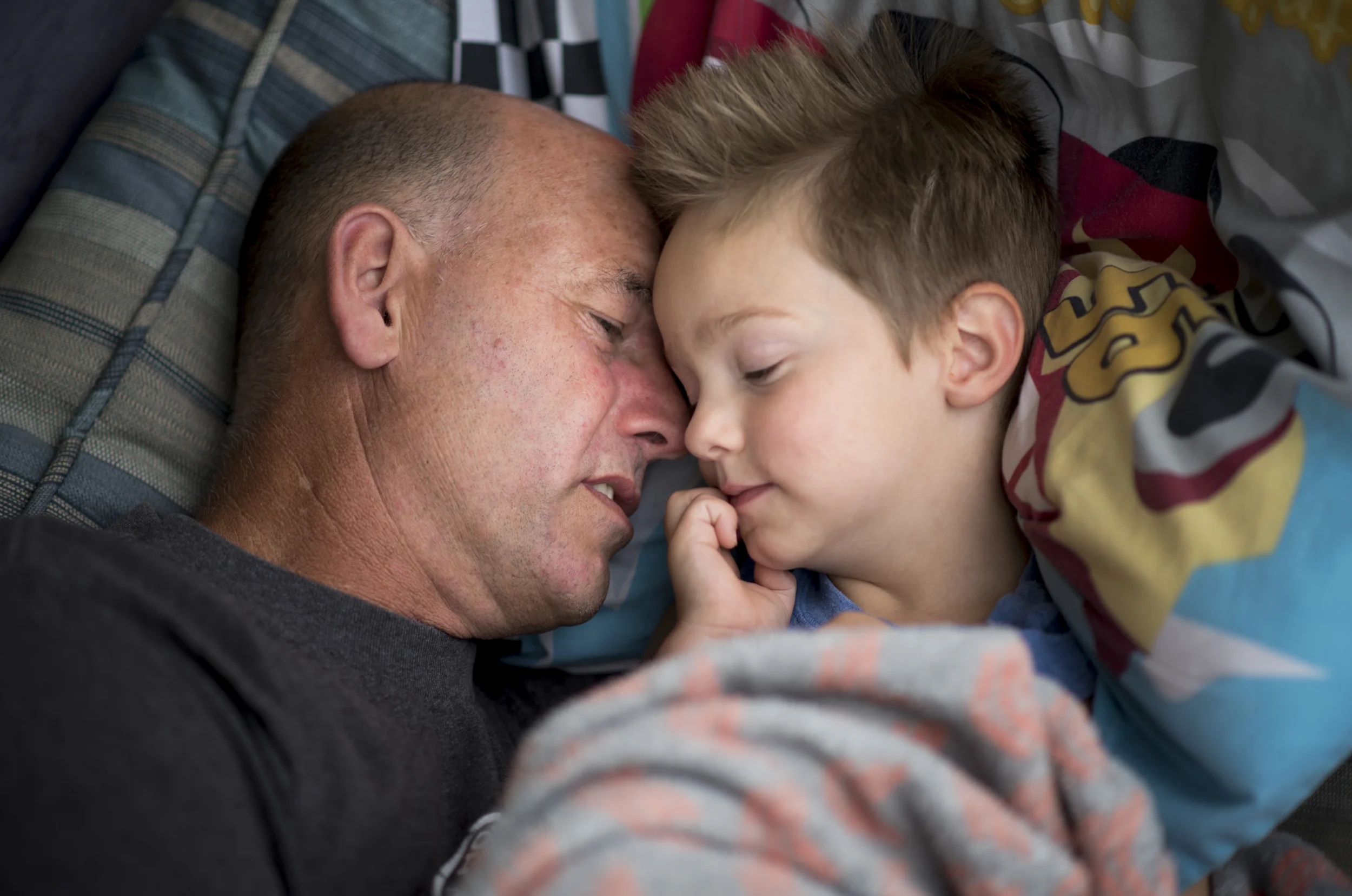   Lyle Fuller whispers to his adoptive son Levi, 3, to fall asleep as they take an afternoon nap together on their front porch on September 25, 2015. Levi was born to a mother addicted to heroin, methamphetamine, alcohol, and marijuana and as a resul
