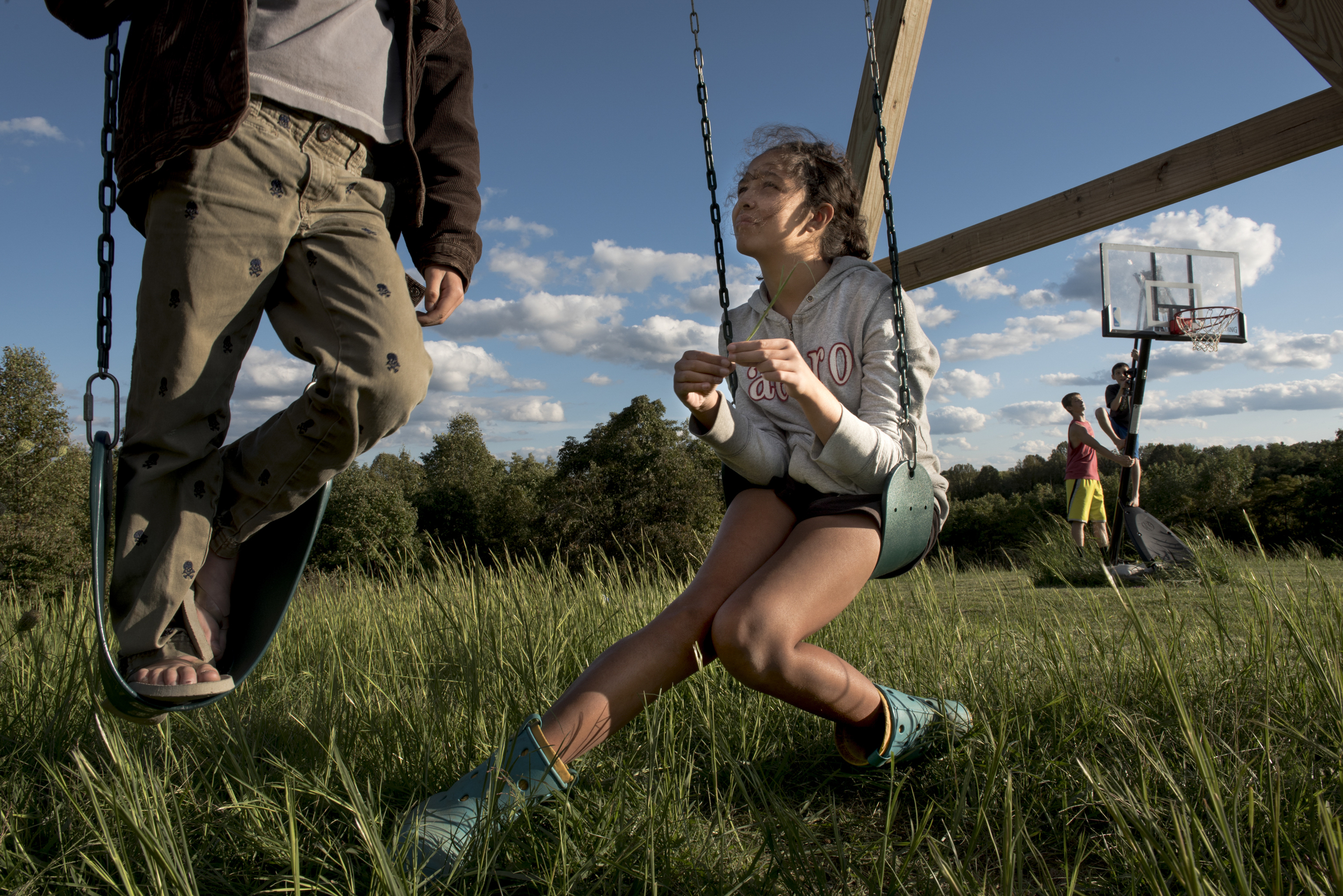  Mya, middle, tells stories with her brother Liam, 11, left, as Gabe, 14, and Keaton play on the basketball hoop in their backyard. Mya was the first adopted child to join the Fuller family after she approaches DJ asking her to adopt her. “All of a s