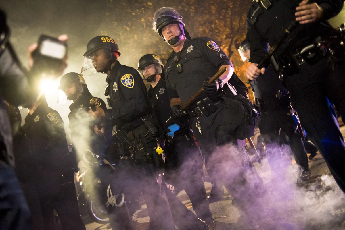 Oakland Police Department riot police push back protesters to get to an unlawful street fire during an anti-Trump protest in downtown Oakland on November 9, 2016.