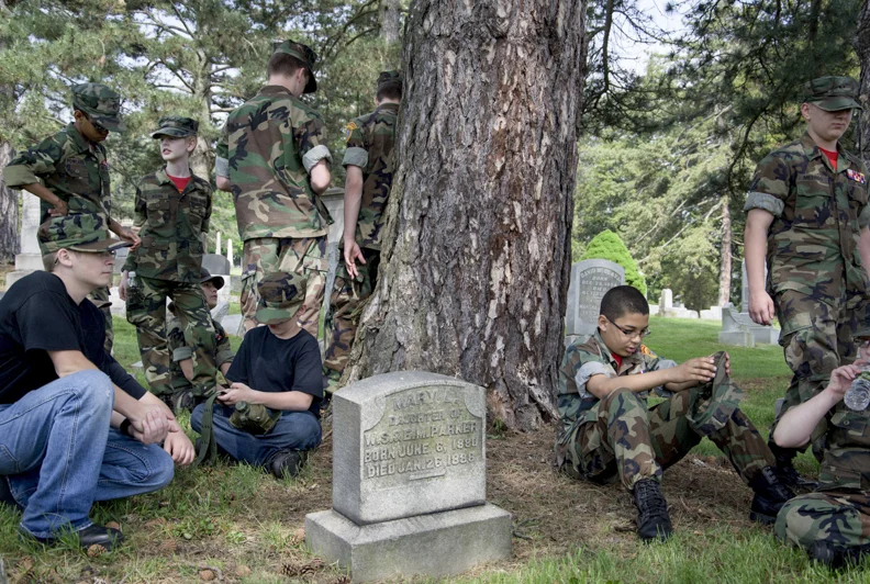  The Washington County Young Marines rest after placing flags on the gravestones of veterans. 