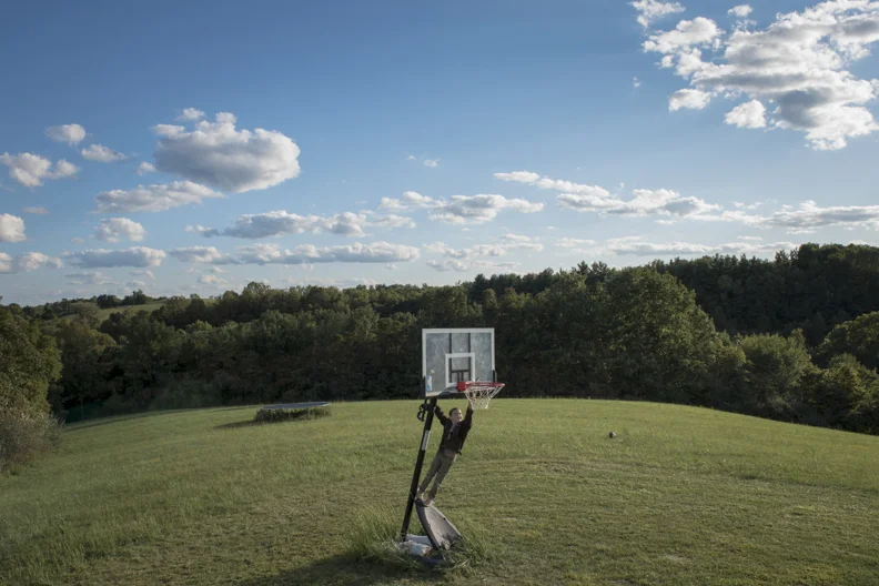  Liam Fuller reaches to fix the basketball net in his yard in Athens, OH. 