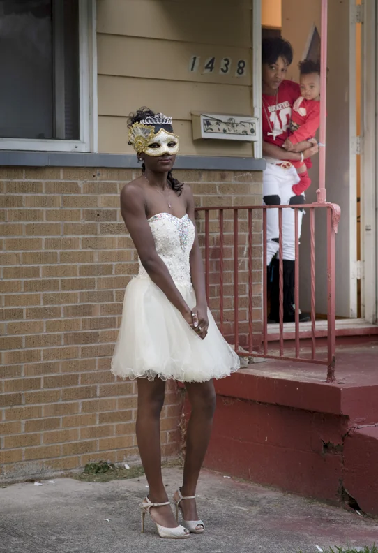  Linden-McKinley STEM Academy homecoming queen Michelle Burns poses for a portrait outside of her home in Linden while her aunt Debbie Randall and her aunt's son Marcus Burns watch from the doorway on Friday, October 16, 2015. 