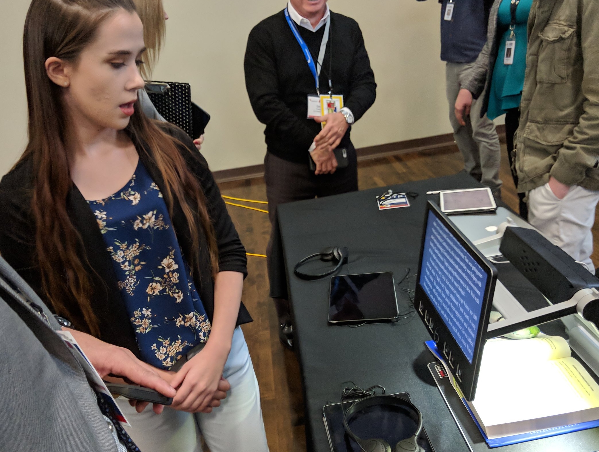 A student demonstrates the assistive technology that helps her read paper texts.