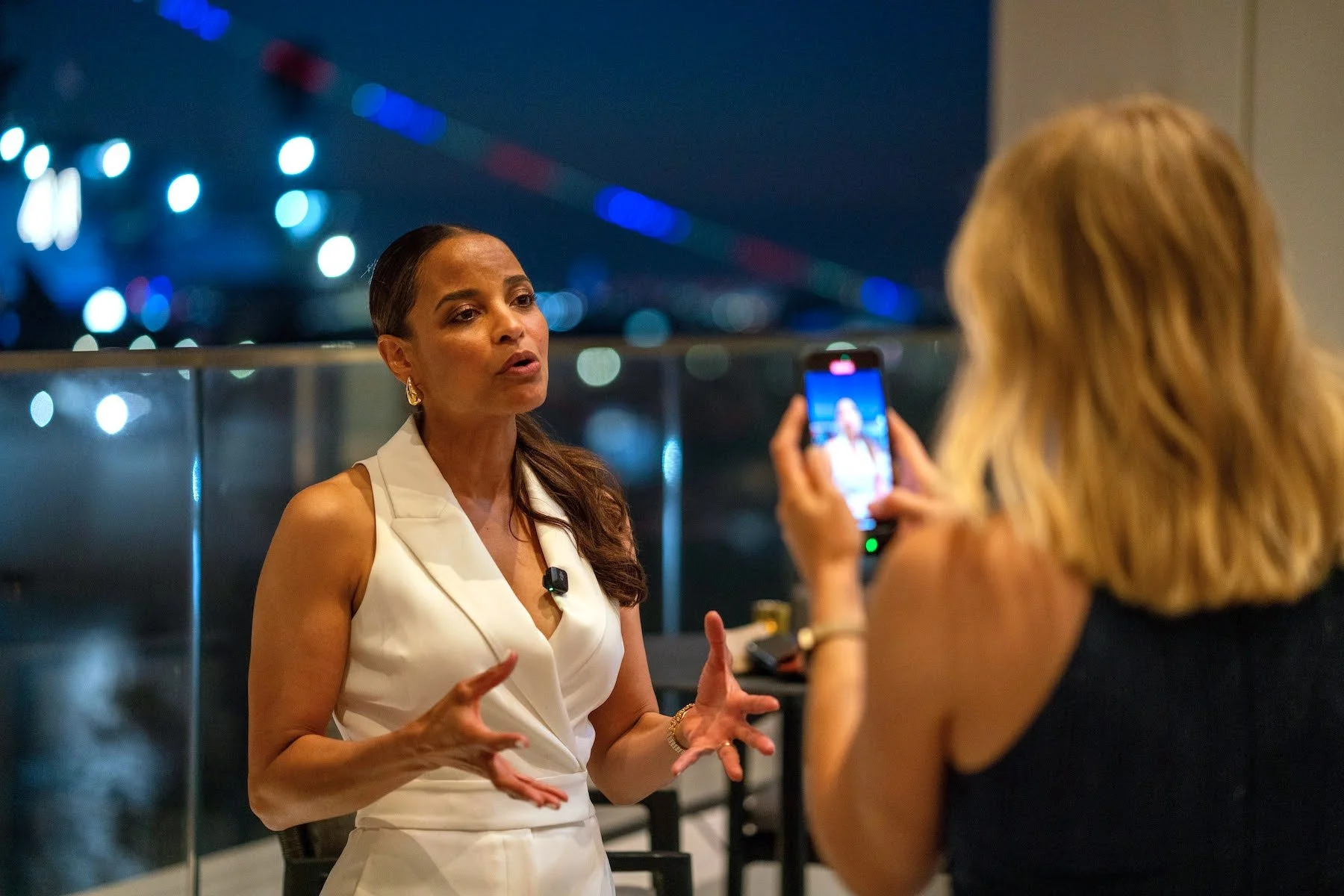 Cara from Left Lane Digital recording a mobile video of a woman speaking during a client event