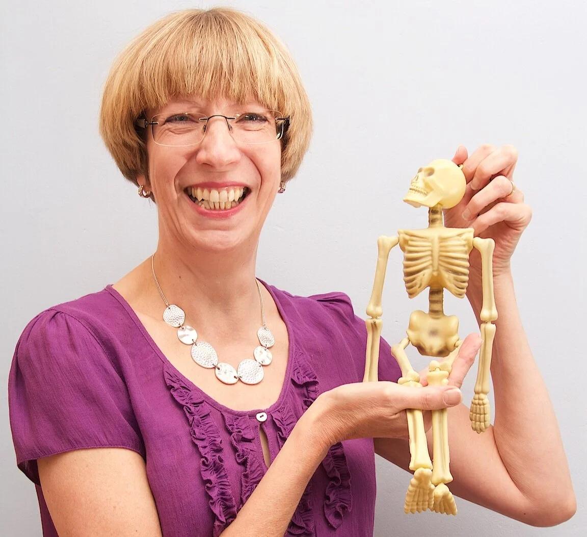 Posture expert Alison smiling with small skeleton in hands