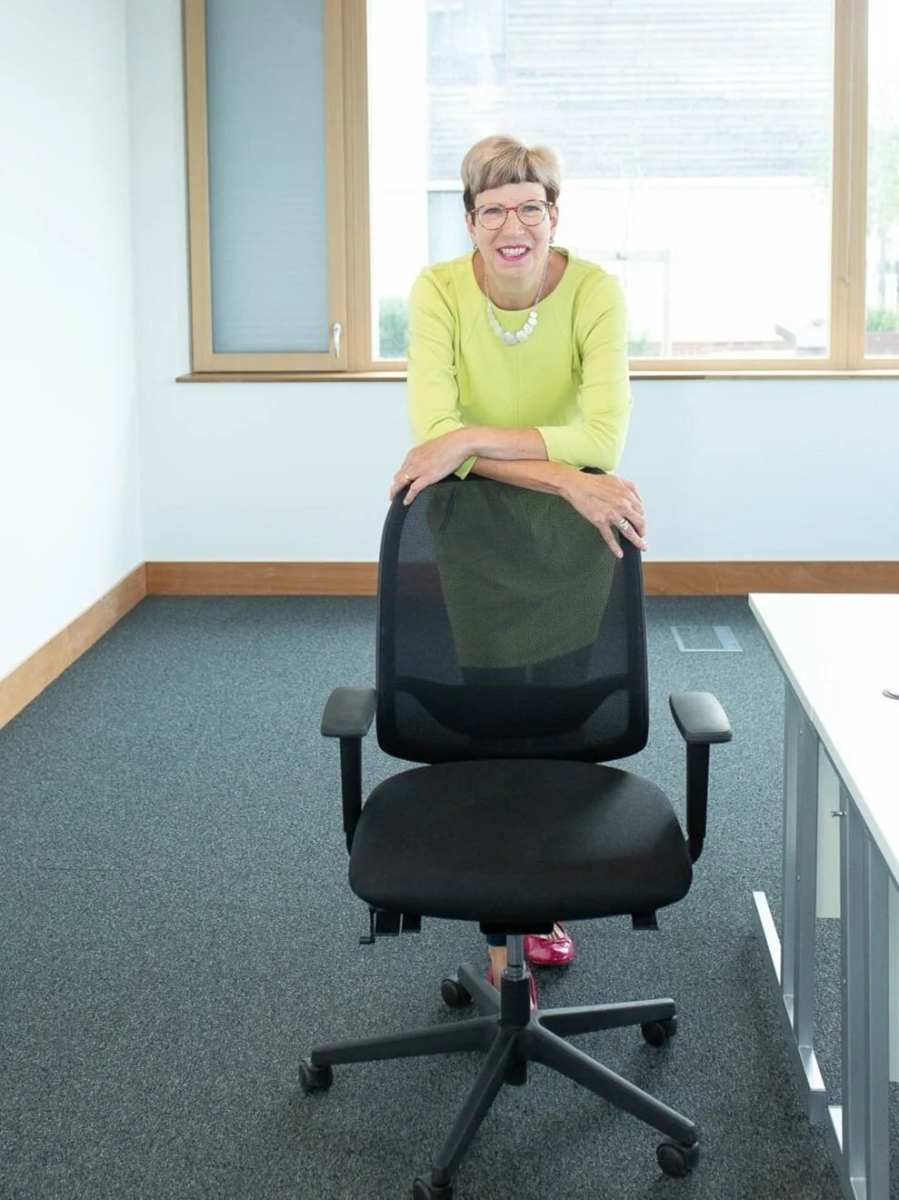 Posture expert Alison standing behind an office chair