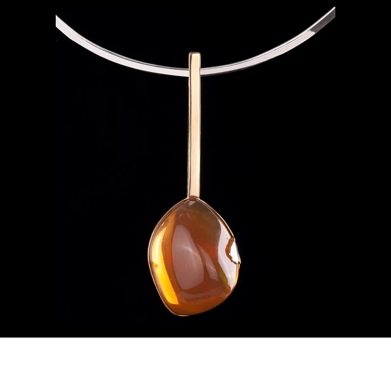 An uncommonly large 80 ct fire opal (Ethiopia) with exceptional play of color. Pendant is accented by 18k gold, with a 925 silver choker