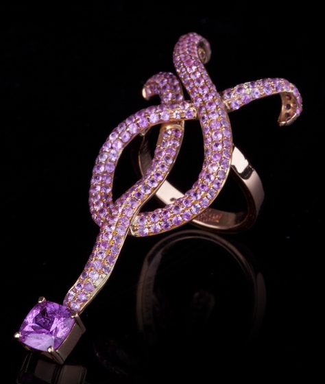 Pink Sapphire Knot Ring A sinuous “knot” ring of double rows of princess-cut pink sapphire pavé, finished with a pink sapphire (4.8 cts). The ring is set in 18k rose gold