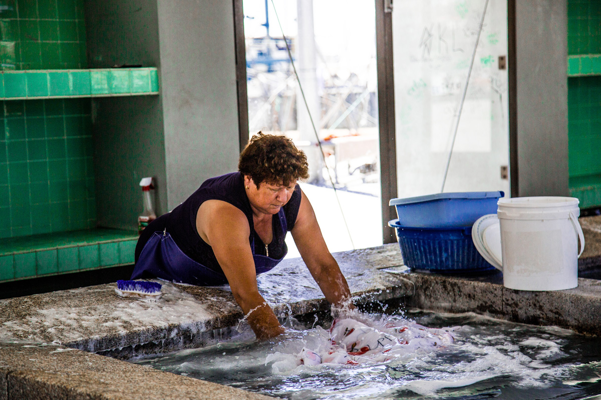  a local woman washing clothes at the public laundry house 