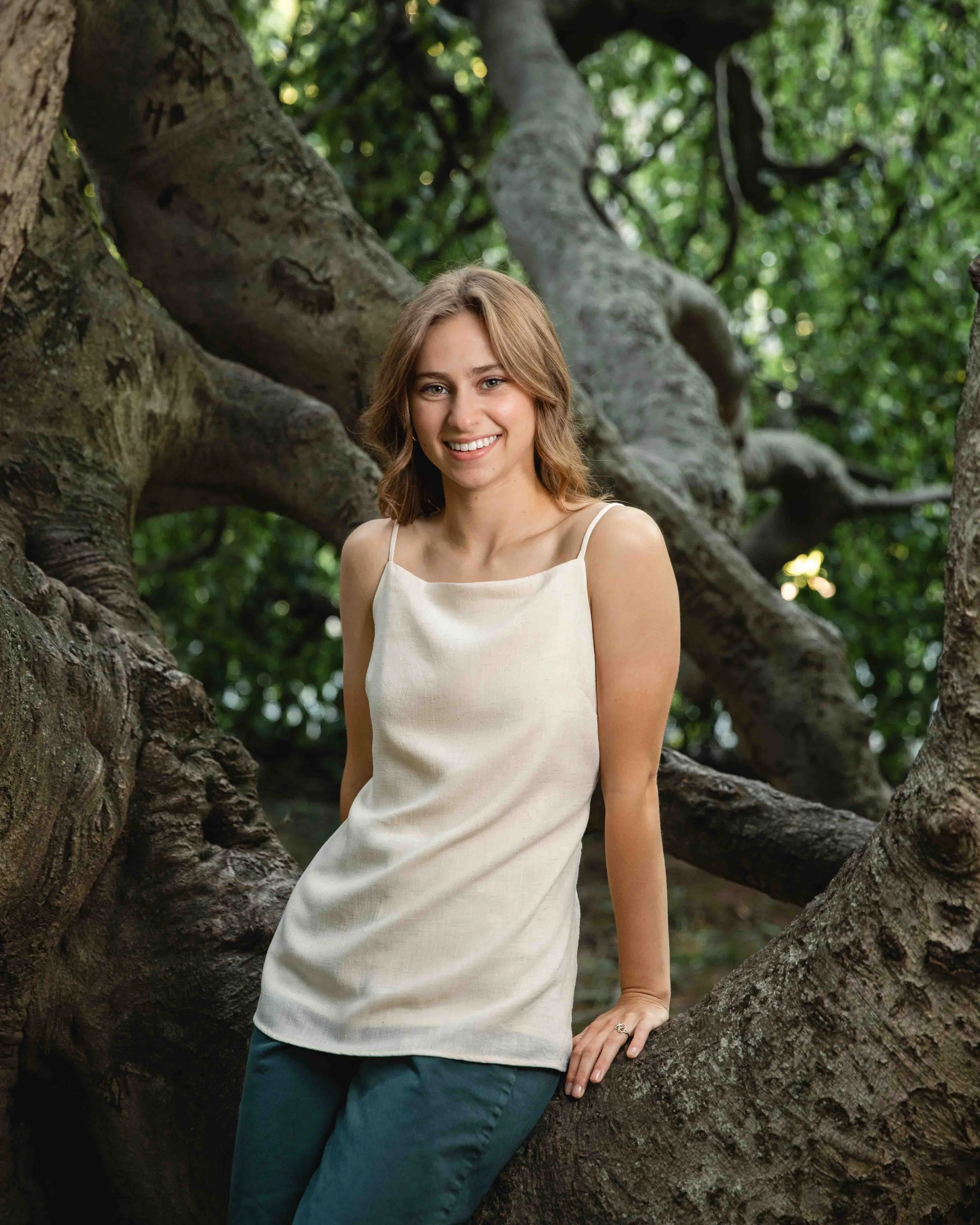 Ohio high school senior smiling during a photo session against an upside down tree at Kenyon College..