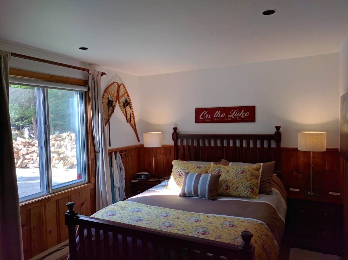 The second bedroom with Queen bed. Note the well-stocked wood pile outside!