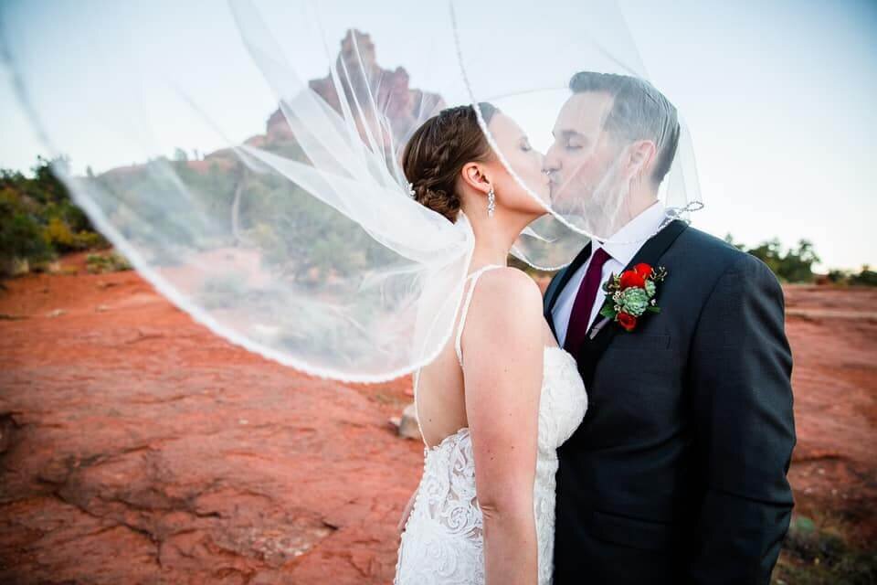 Sedona wedding coordinator bride and groom kissing under veil.jpg