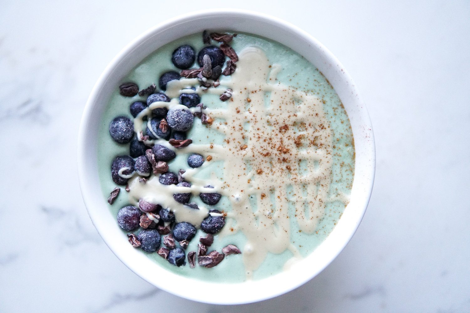 Matcha smoothie bowl with a generous tahini drizz