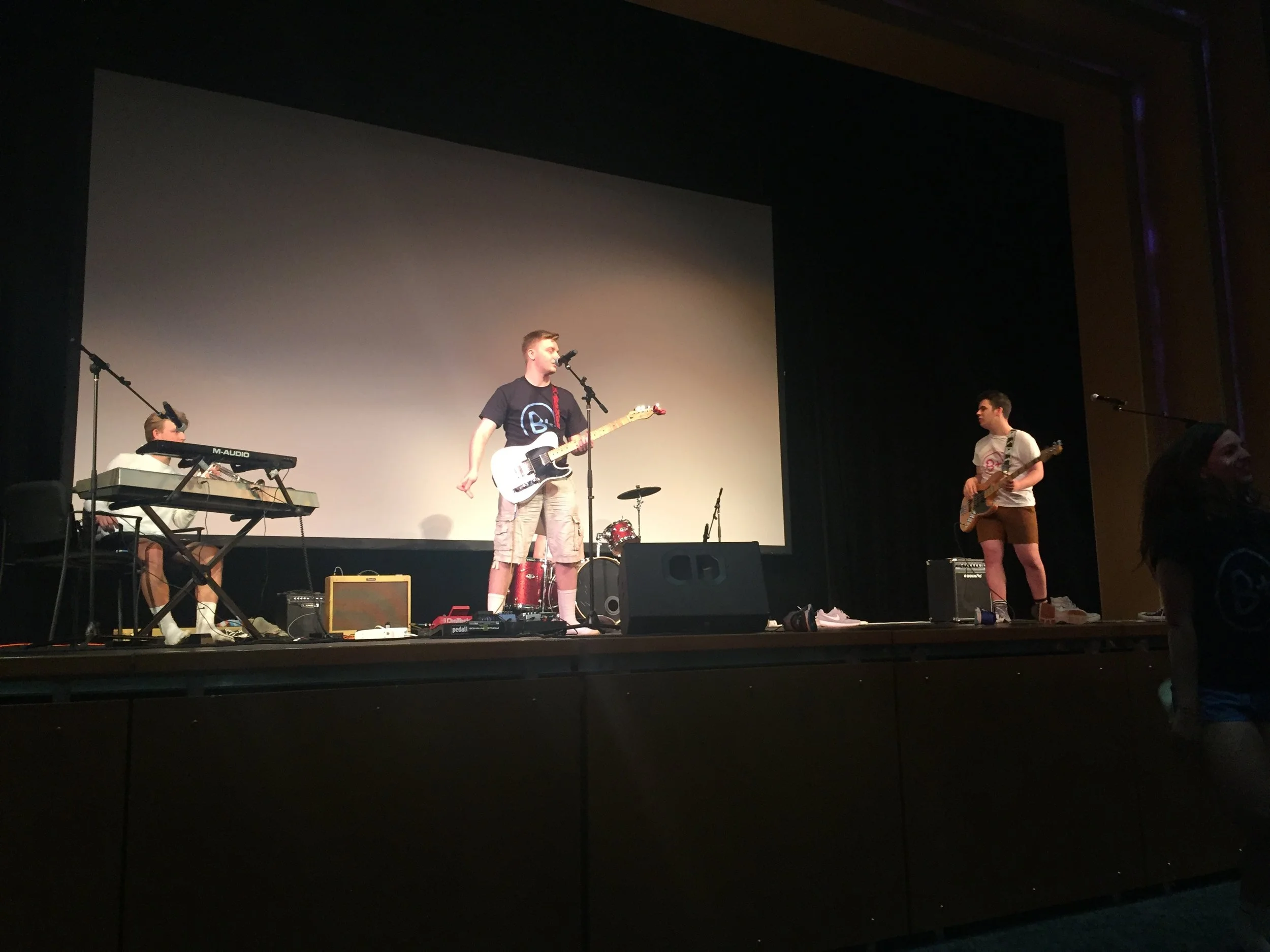 Shooting Shark, a rock band composed of Charter students Ethan Andress (left), Nate Lamborn (center), Evan Kipp (behind Lamborn), and Brian Johansson (right) performing in the Cab Calloway theater at CHVRTERTHON. Photo by Grady McPeak