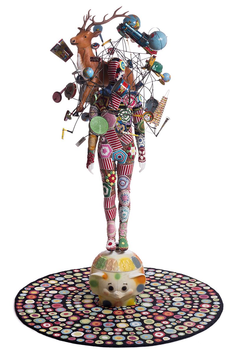 Nick Cave, Soundsuit , 2015, mixed media including vintage toys and globes, wire, fabric, rug, metal and mannequin, Soundsuit: 117 (H) x 50" (W), Rug: 85" diameter, Inventory #NC15.007 ©Nick Cave. Photo by James Prinz Photography. Courtesy of the artist and Jack Shainman Gallery, New York.