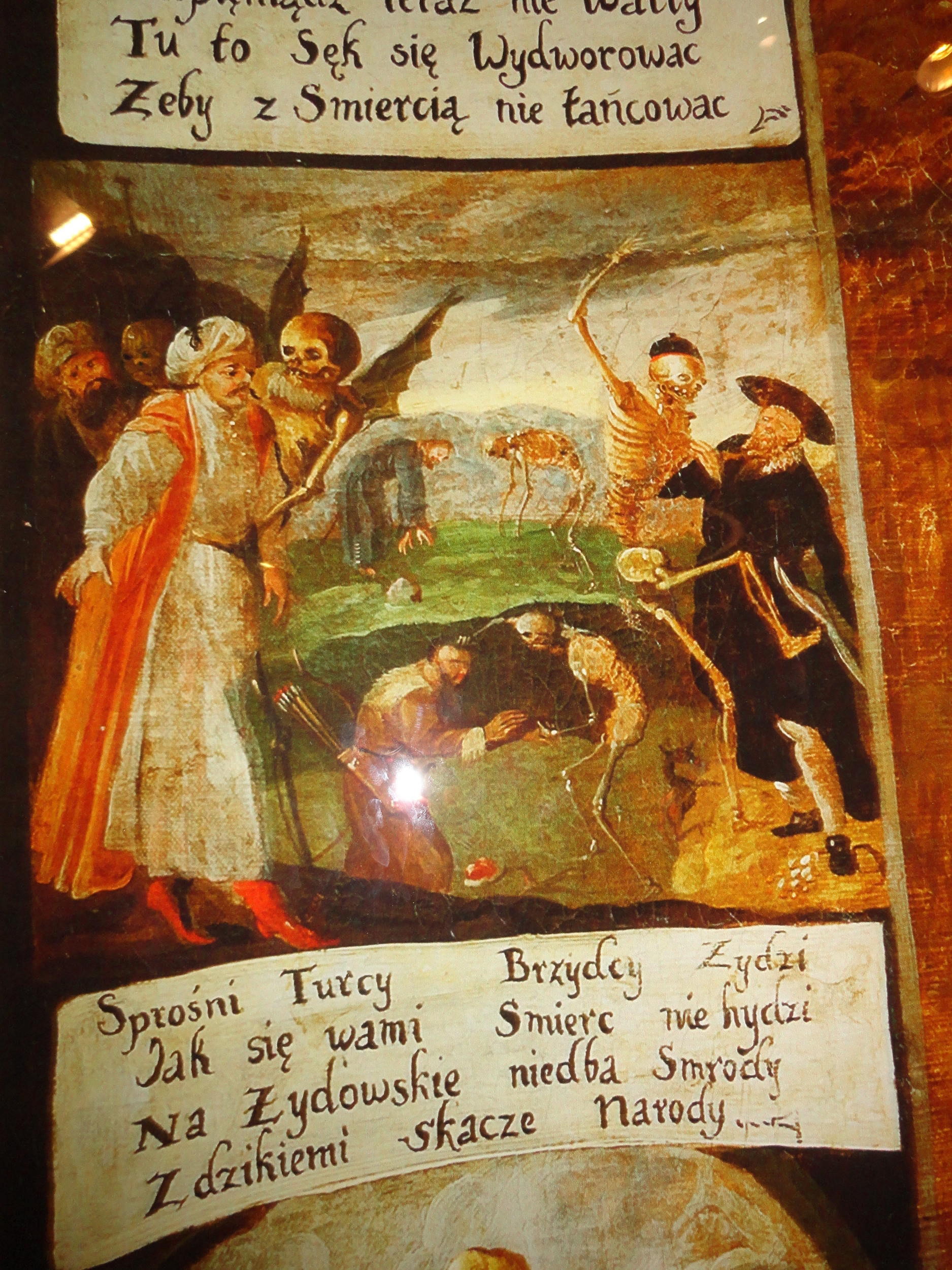 Inset from mural at POLIN. Text says "Disgusting Turks and ugly Jews/ Death is not repulsed by you./ She pays no heed to the Jewish stench/ And capers with the savage nations.