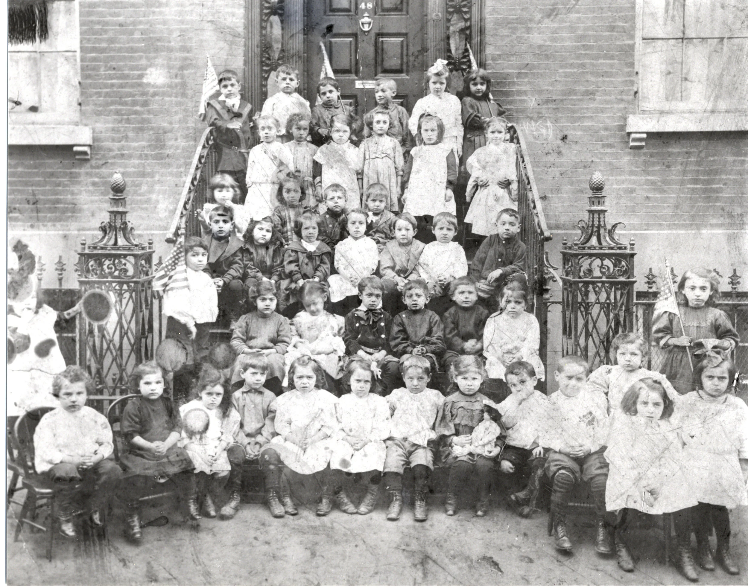 Sol Napolsky at the Henry Street Settlement House kindergarten, 3rd row, right, leaning against bannister.