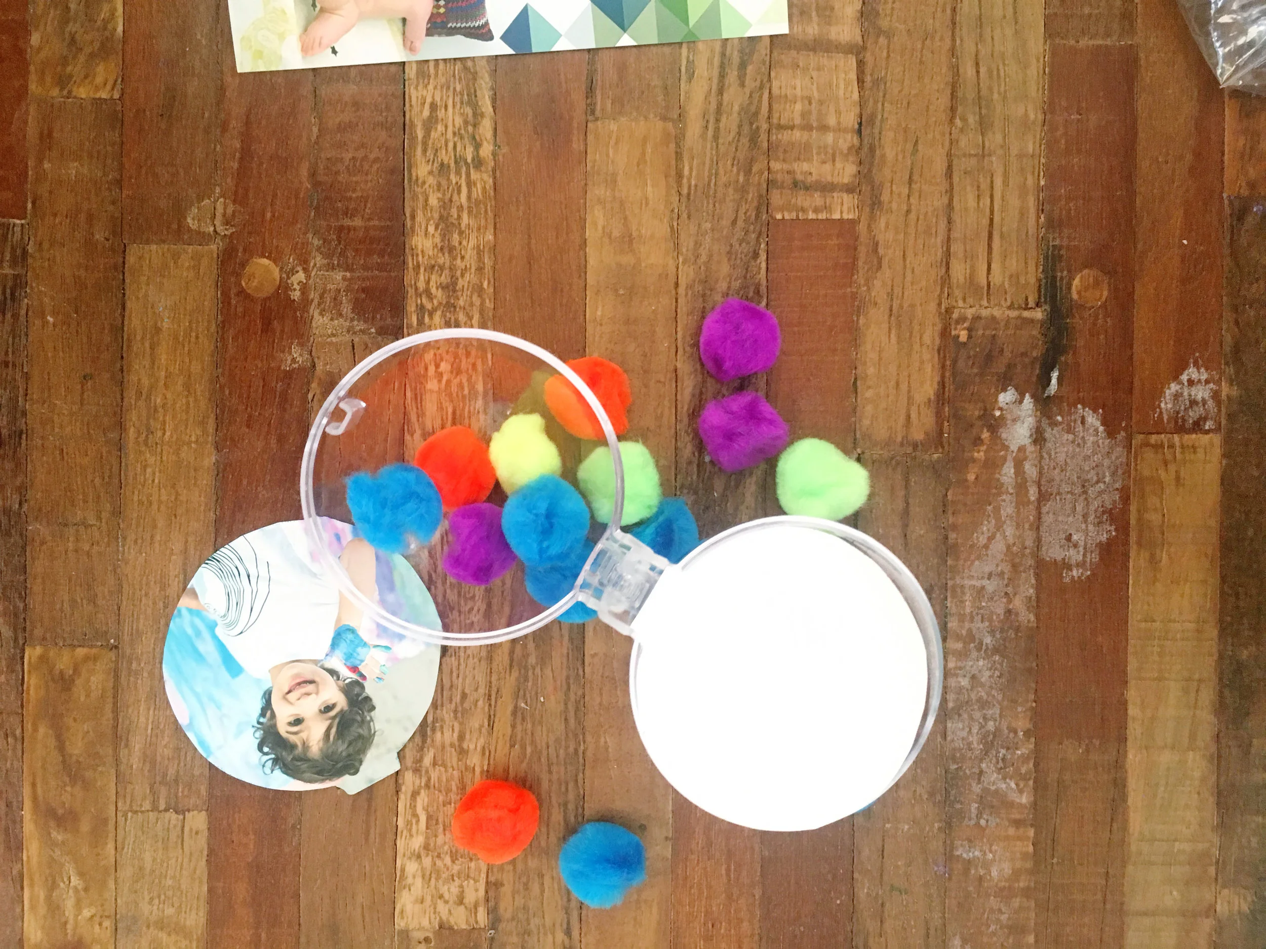 8. You can also fill up the ornament with fun decor like these colorful pom poms we used! We also used mini feathers for the other side of Hunter's ornament.