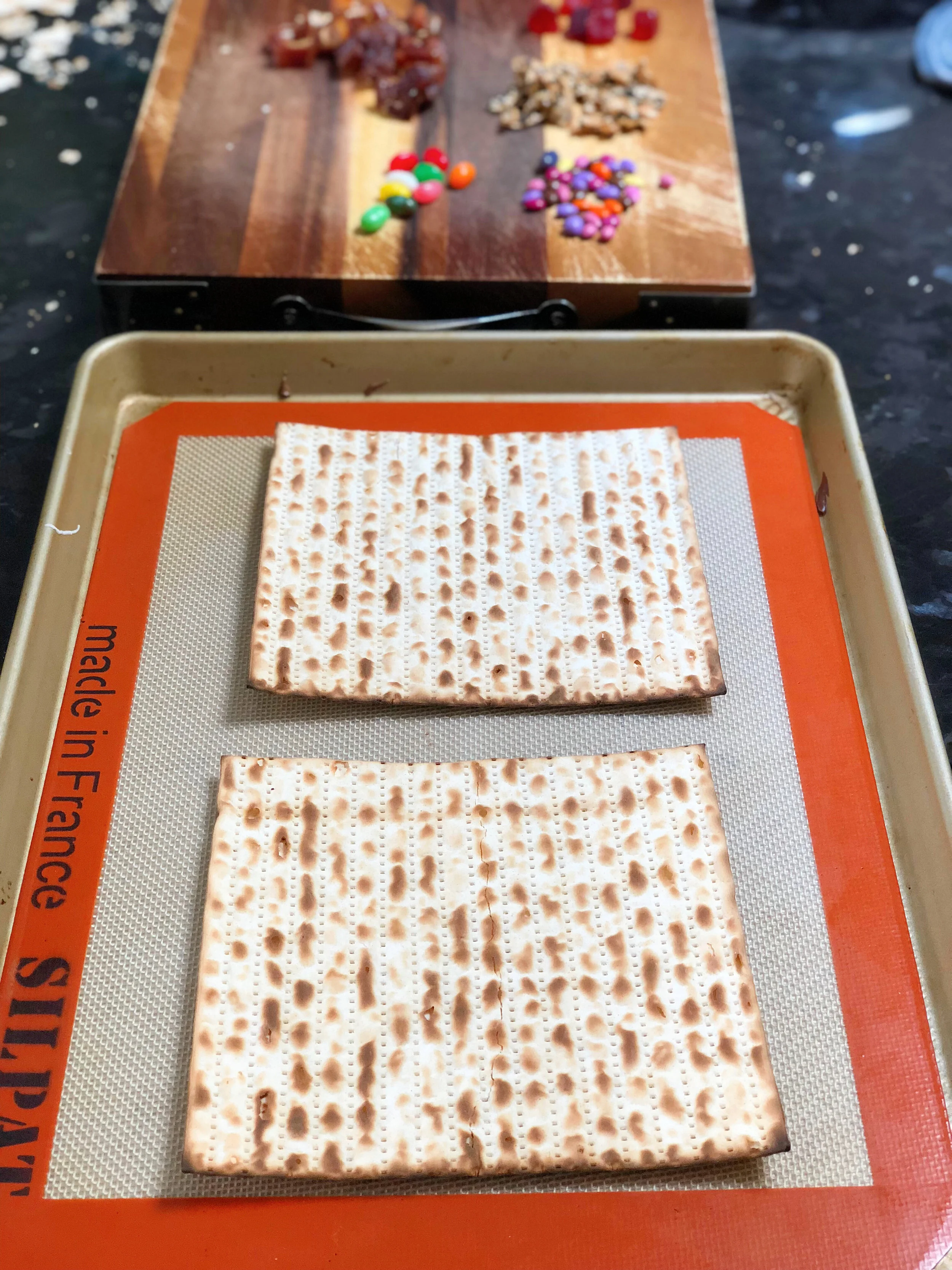 1. Place two pieces of matzah onto a sil pat (or parchment paper) lined sheet pan.