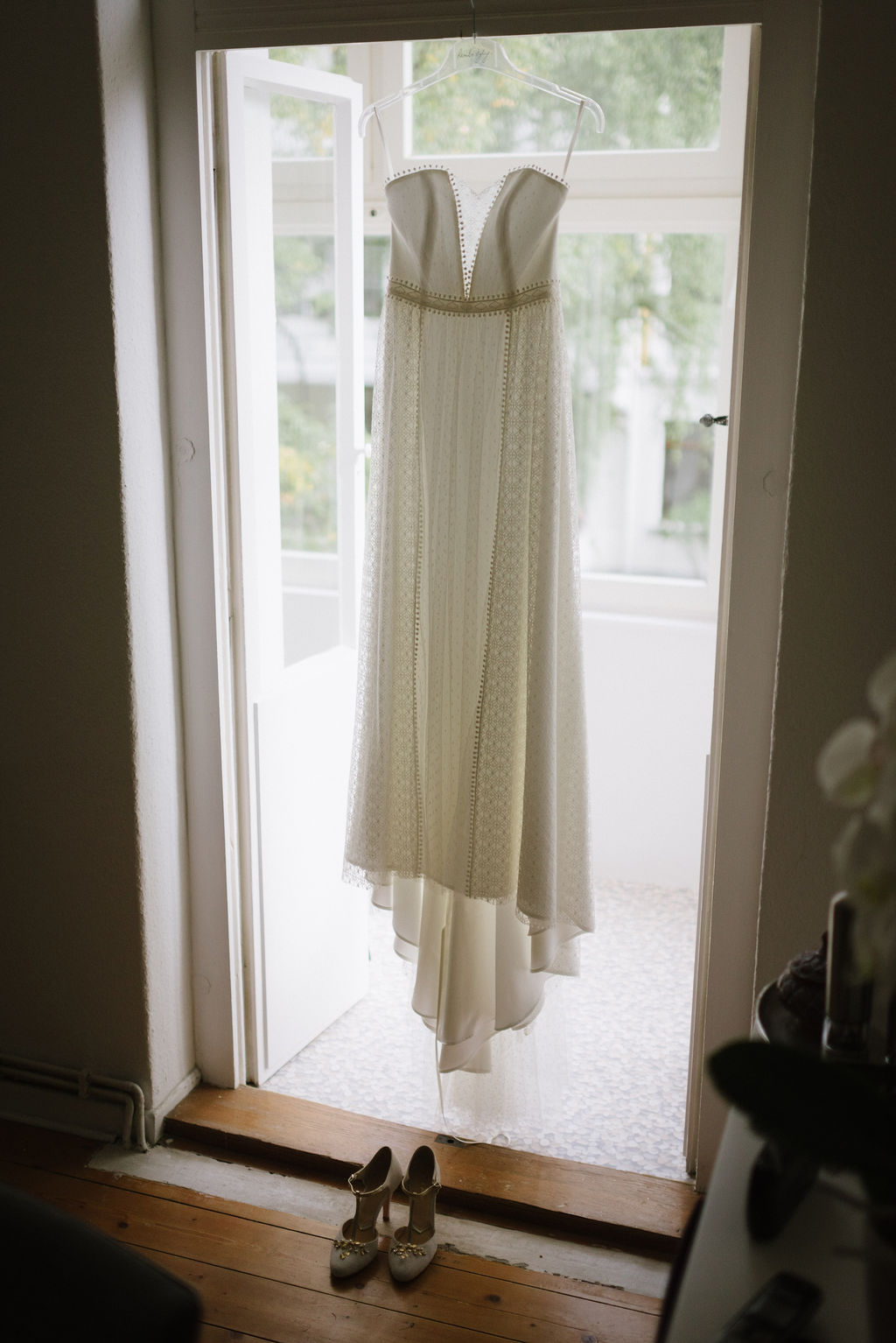 Brautkleid und Brautschuhe am Fenster