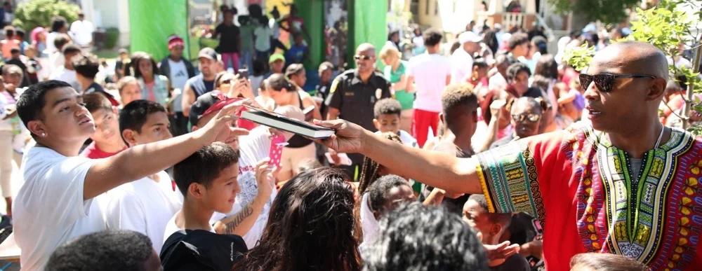 Caron Handing Book to Kid in Racine.jpg