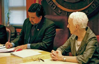 Representative Gail Chasey , looking on as Governor Richardson signs the bill repealing the death penalty.