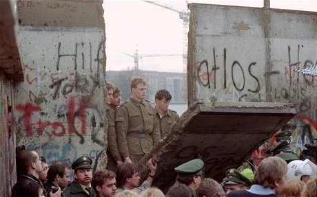 Demonstrators pull down a segment of the Berlin wall at Brandenburg gate in 1989