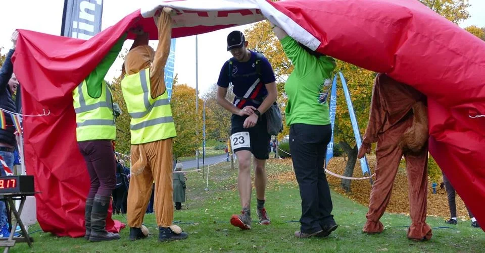 Top team welcoming the runners home under a deflated finish sign