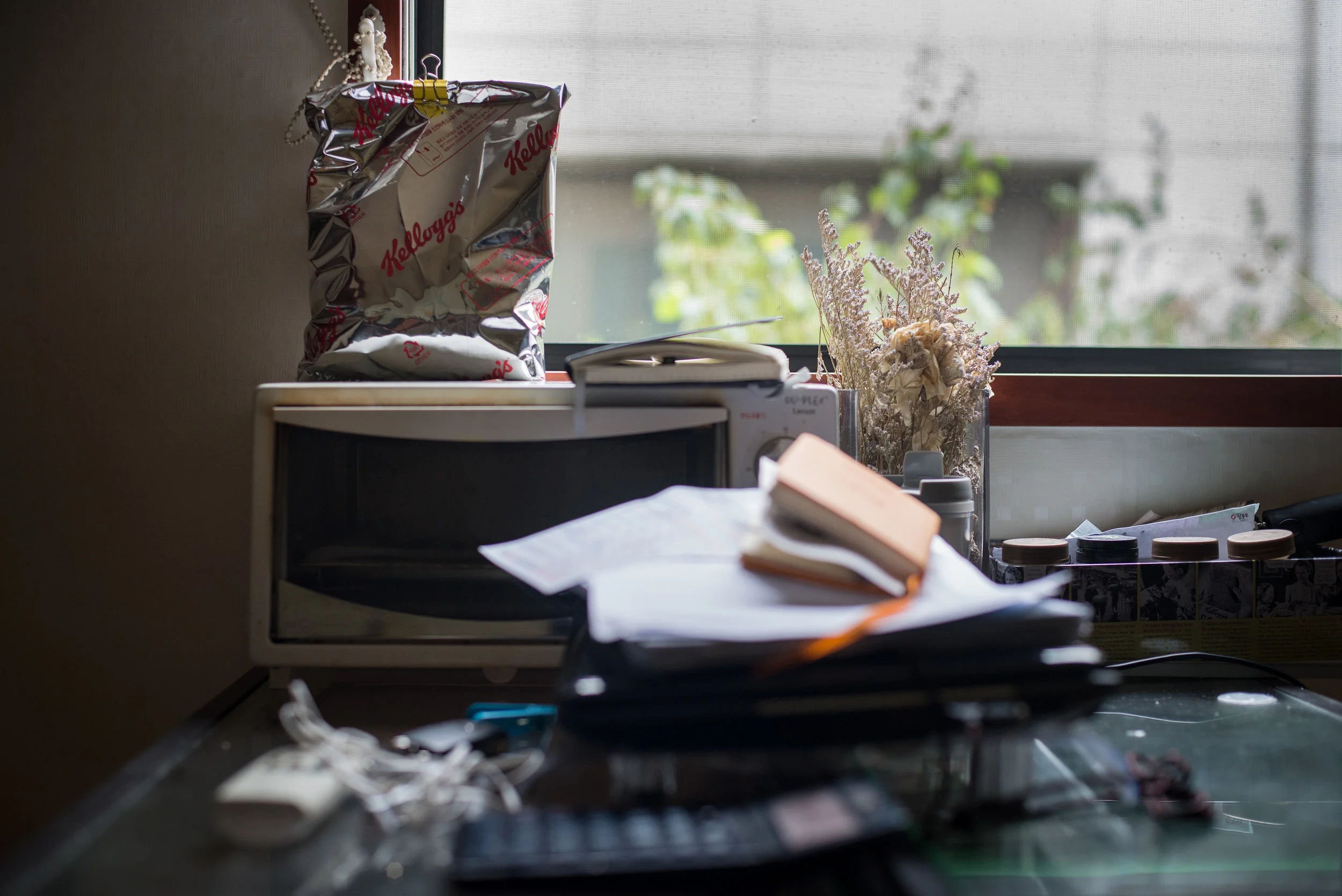 Mr Choi’s dining table is piled high with notes from his English lessons. This area is where he does his work, eats and watches videos to relax.