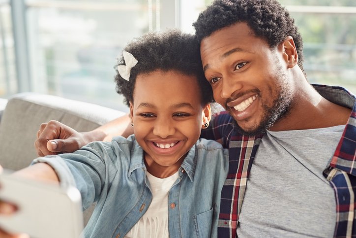 Black man with daughter taking selfie.jpg