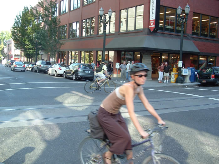 Streetcar tracks and bicyclists travel by Powell’s Books.