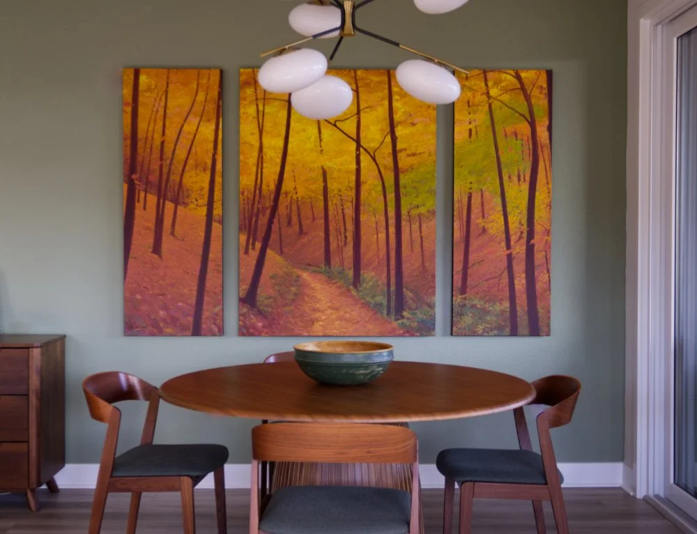 Three-paneled painting of autumn forest in upscale condo dining room