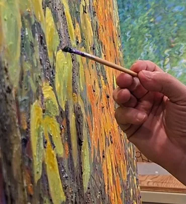 Closeup of Stephen Henning applying paint to Where Autumn Gathers Light, showing thick layered brushwork and textured contemporary Impressionist surface in autumn colors.