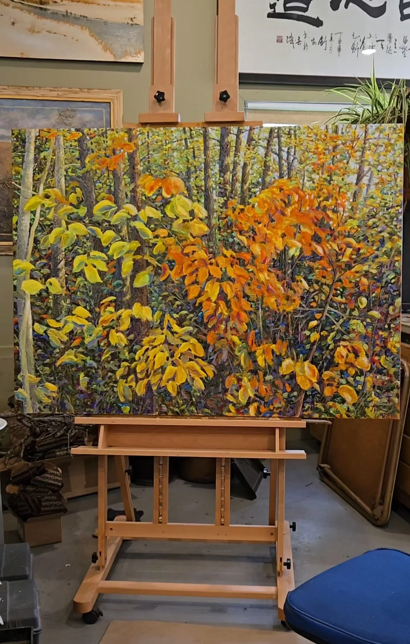 Where Autumn Gathers Light on the easel in Stephen Henning’s Minnesota studio, showing layered contemporary Impressionist brushwork and luminous autumn foliage inspired by filtered forest light.
