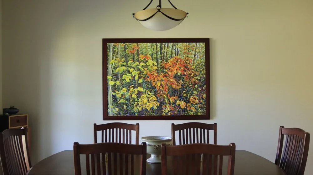 Large autumn forest painting Where Autumn Gathers Light installed in a dining room in an Ohio home.