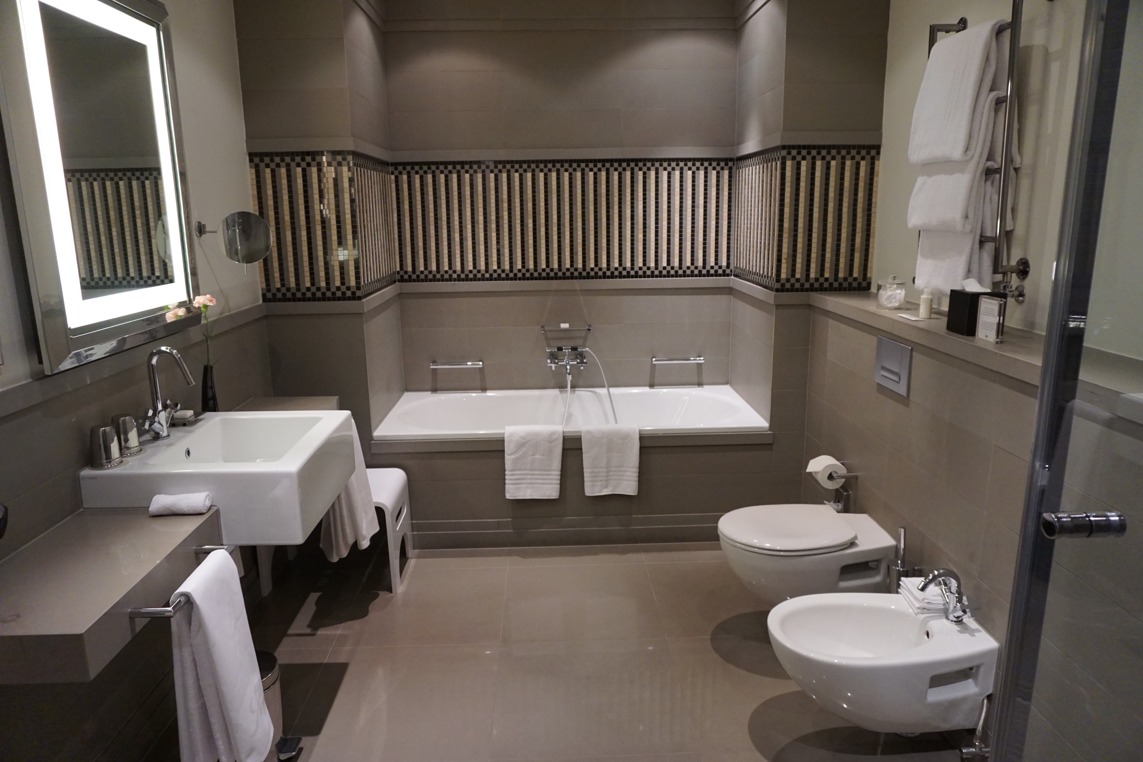 Die großen Marmorbadezimmer sind mit Mosaiken dekoriert und verfügen über eine Badewanne sowie eine separate Dusche mit Sitzgelegenheit. Auch sehr positiv, da ich immer friere: die Fußbodenheizung. Der Spiegel wurde mit viel Sorgfalt und Liebe ausgewählt. Selten habe ich so gut und frisch in einem Hotelbadezimmer ausgesehen. Das Licht kommt von vorne. Ganz einfach, wird aber in anderen Häusern selten so umgesetzt. Perfekt für BeFiftys, vor allem nach langen Berlin-Nächten.