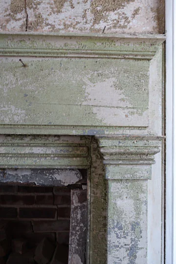 A detail of the fireplace mantel shows the alligatoring of the paint finish, soon to be restored.