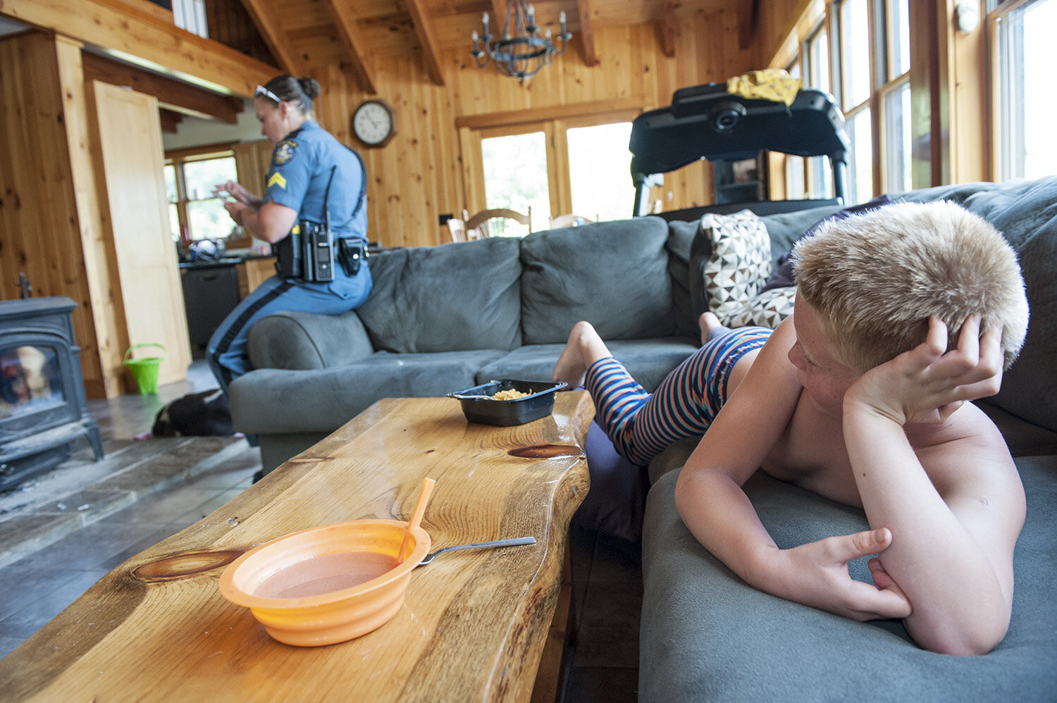 Before heading out for work as a Maine State Trooper, Bethany Robinson sits on the edge of her sofa, pouring over and grumbling about various personal and work texts, while her son Cody, lounges, paying more attention to the fact that his mom needs
