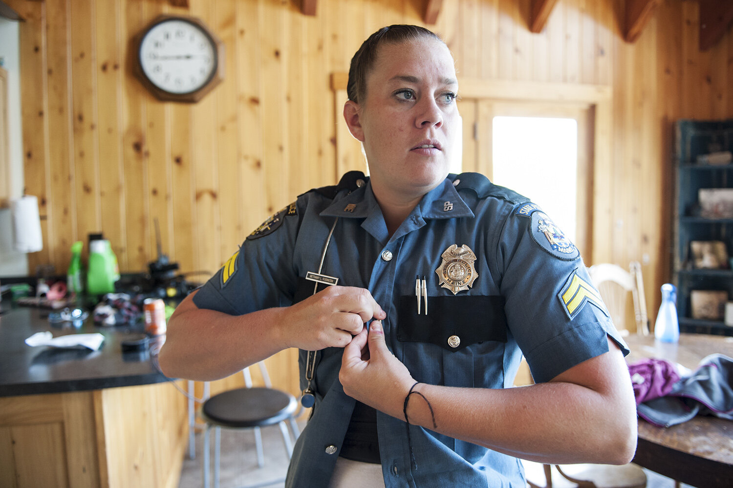 Layers, not just a metaphor for Bethany’s life, but a reality in clothing. Base layer of a bra and white t-shirt, then a bullet proof vest, followed by a wool button up uniform shirt, stretched tightly across her chest. Long black socks, heavy boo