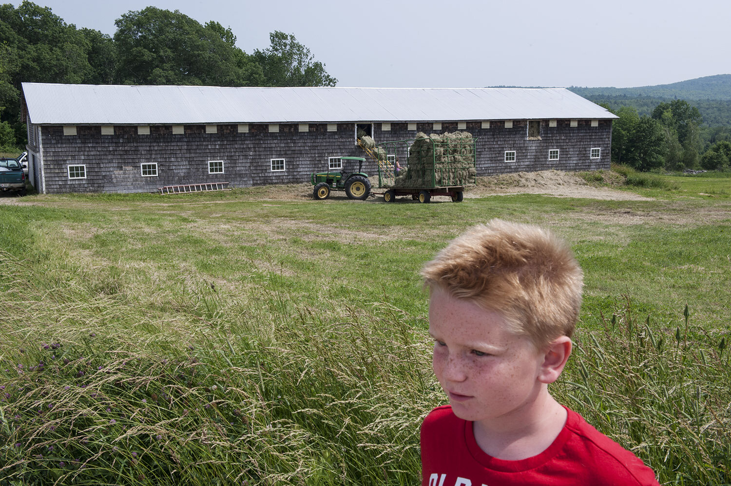 Bethany’s son Cody wonders down from his aunt’s home to see his mom as she loads hay from the trailer into the barn to be stored until it is sold. Cody and his sister Cole often have the freedom to wonder back and forth from house to house as their