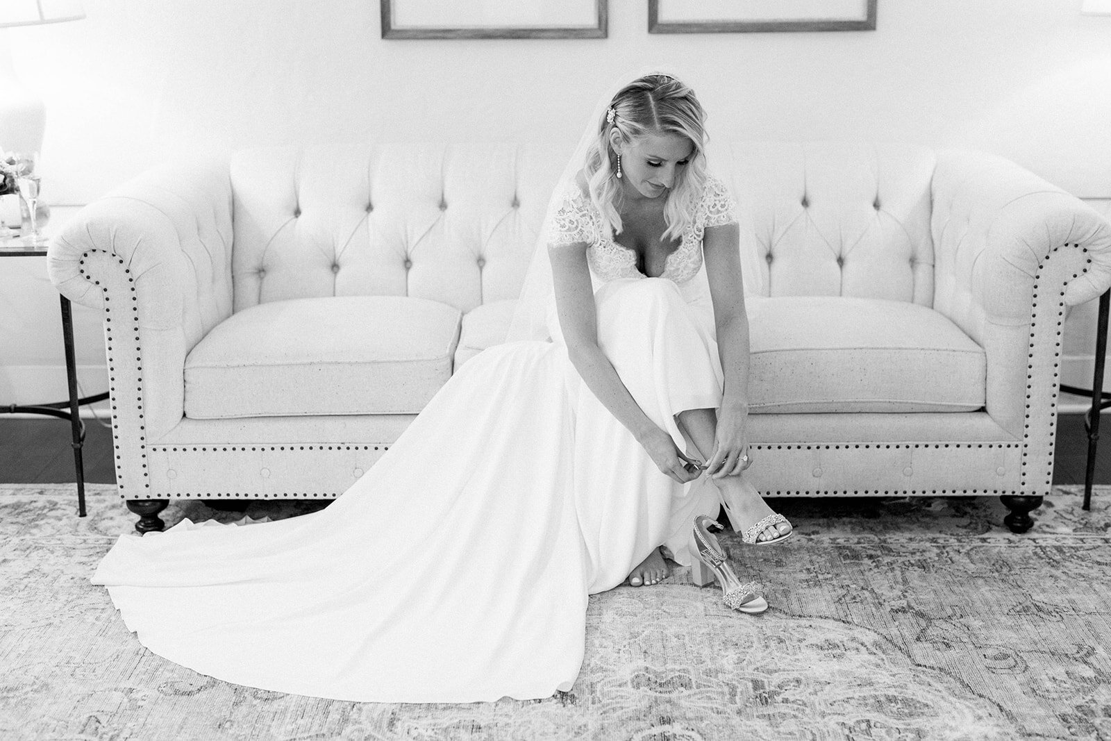 Bride putting on Badgley Mischka wedding shoes: Longue Vue Club Wedding captured by Abbie Tyler Photography