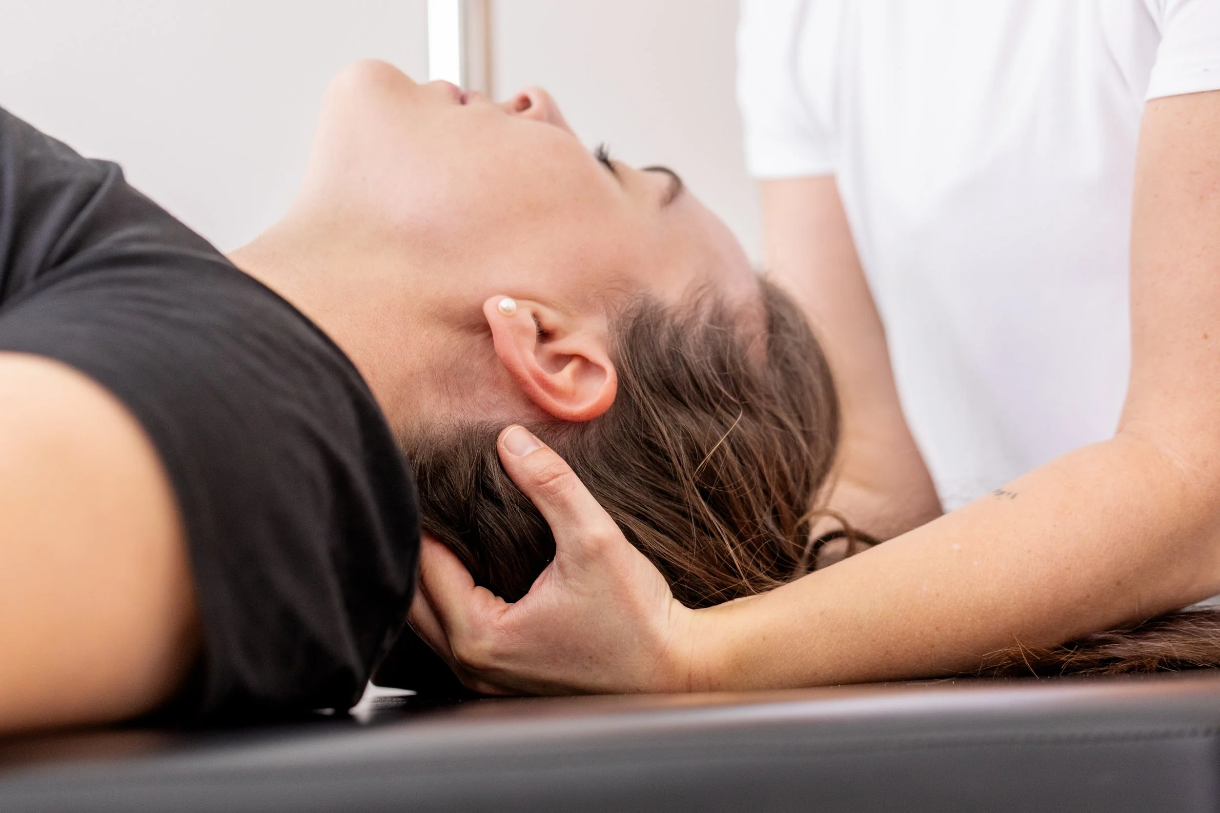 Hands-on bodywork supporting the neck and head during a session