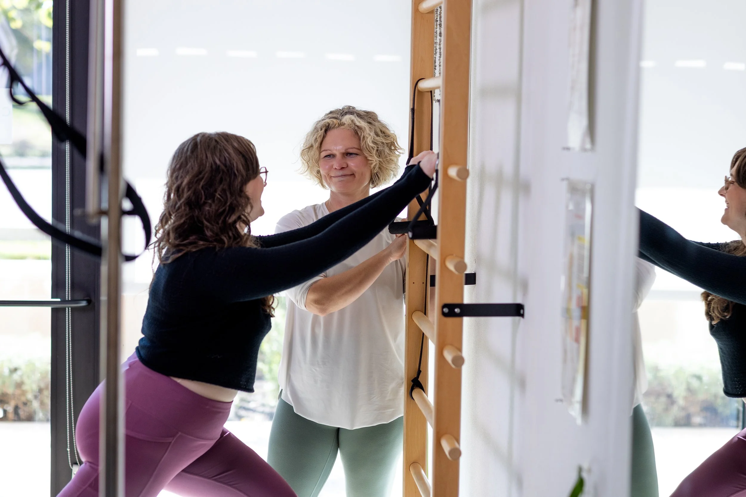 Practitioner guiding a client through a supported movement exercise during a one-on-one session