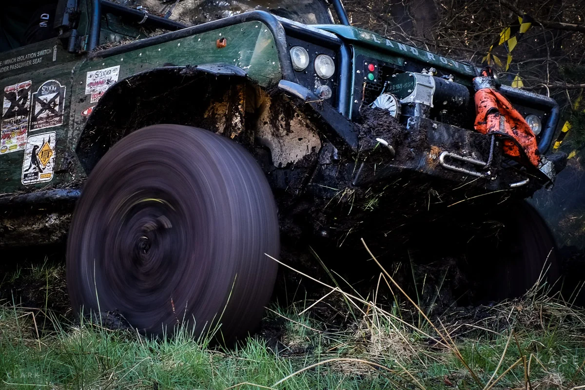 Wheels spin as the Land Rover attempts to pull itself out of a ditch.